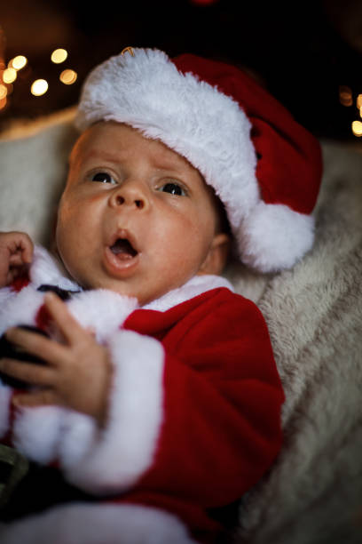 istock Newborn baby in Santa clothes lying under Christmas tree. 1179745741
