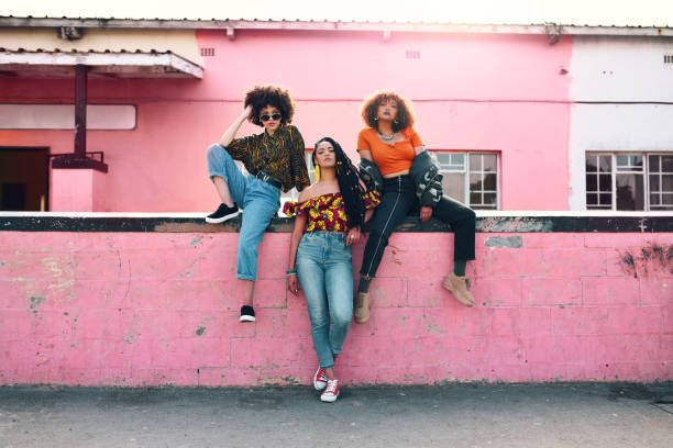 Our style is influenced by our upbringing Full length shot of three attractive and stylish young women posing together against an urban background street style stock pictures, royalty-free photos & images