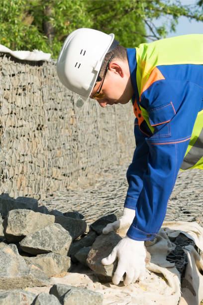 istock builder in a yellow vest and white helmet takes a stone 1179747968