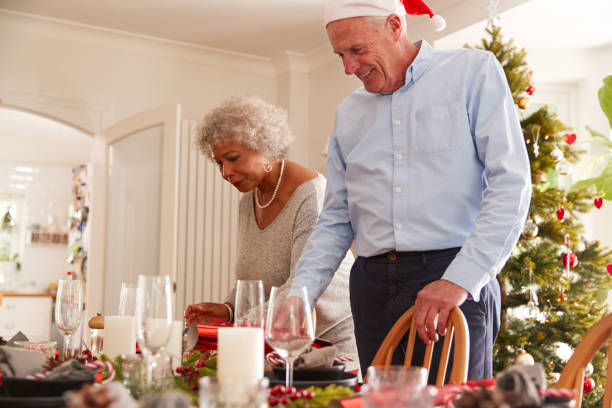 istock Senior Couple At Home Setting And Decorating Table For Meal On Christmas Day 1179748438