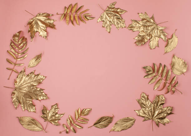istock Autumn frame made of gold leaves on pink background 1179748558