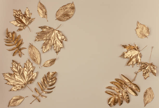 istock Autumn gold leaves on beige background. 1179748586
