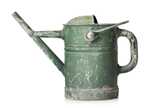 Old metal watering can on white background.
