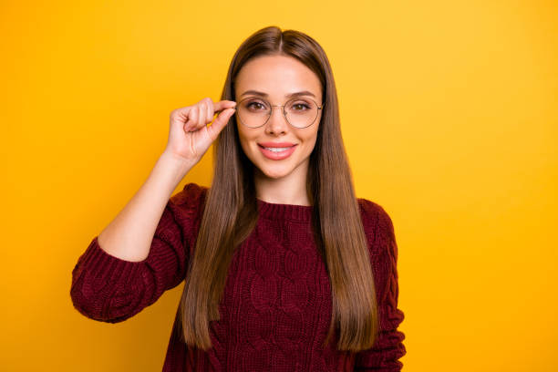 istock Portrait of charming lady touching her specs smiling wearing marsala pullover isolated over yellow background 1179750019