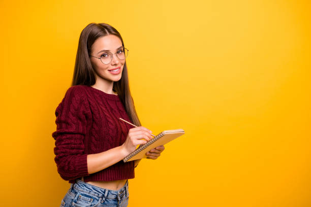 istock Profile side view portrait of her she nice attractive charming winsome brainy cheerful straight-haired girl writing notes plan isolated over bright vivid shine yellow background 1179750048