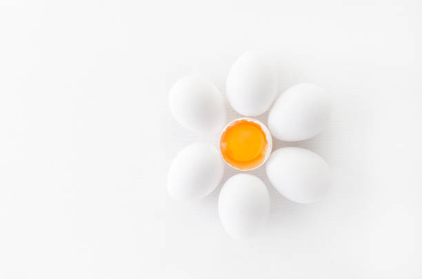 istock fresh white eggs with yolk on white background, flat lay 1179753824