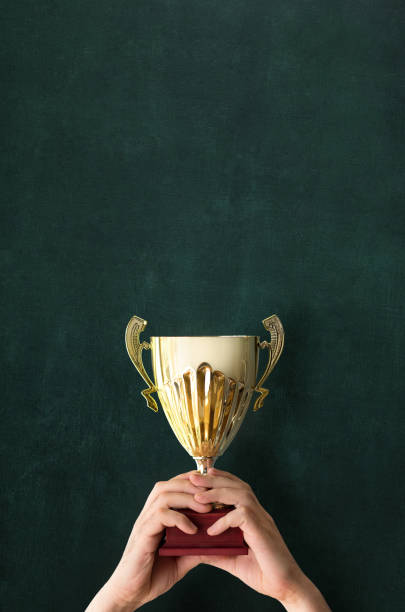 istock Holding up a trophy cup as a winner 1179753834