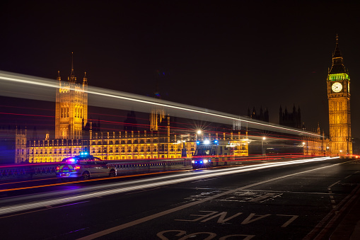 Police, ambulance emergency vehicles at night on Westminster Bridge by Big Ben, Houses of Parliament, London, England