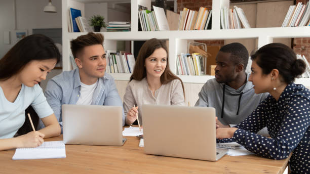 istock Happy female team leader sharing knowledge with diverse university friends. 1179756343