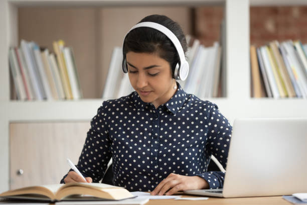 istock Focused indian female student preparing for exams, wearing headset. 1179756393