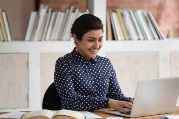 istock Smiling young girl working on school project with computer. 1179756394