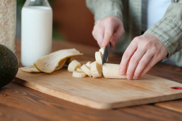 istock Girl cuts a banana for smoothie. 1179756414