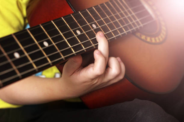 istock Children's hand and guitar strings, learning to play 1179757263