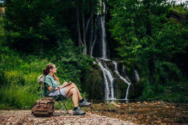 istock Woman biologist taking notes by the waterfall 1179757618