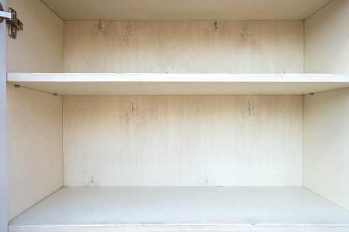 Empty shelves in white wooden cupboard. Blank bookcase.