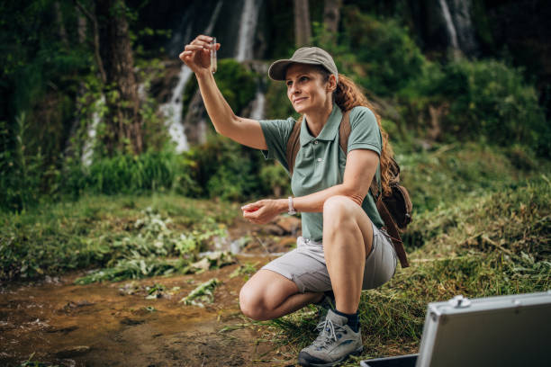 istock Woman biologist taking a water sample in nature 1179758583