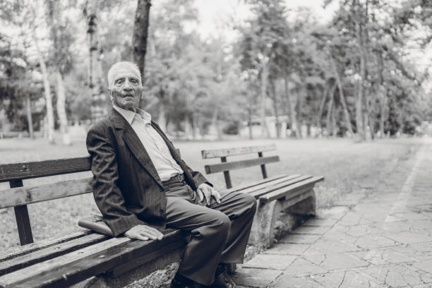 istock Senior man sitting on a park bench 1179758733