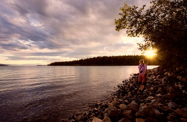 istock Young woman on lakeshore enjoying sunset 117975966