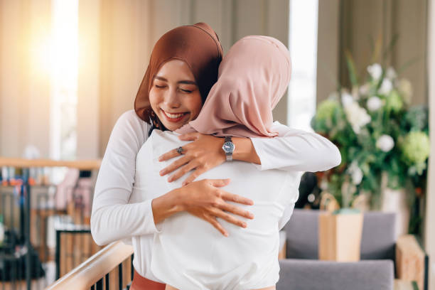 Portrait of young Asian muslim women in happy smile with hijab or head scarf hugs each other indoors Portrait of young Asian muslim women in happy smile with hijab or head scarf hugs each other indoors. Love and happiness concept indonesian culture photos stock pictures, royalty-free photos & images