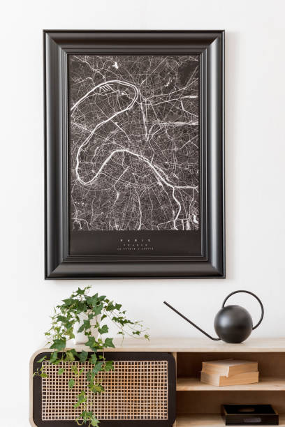 istock Modern scandinavian living room interior with black mock up poster map frame, design commode, plant, books and elegant accessories. Template. Stylish home decor. White wall. Minimalistic. 1179759994