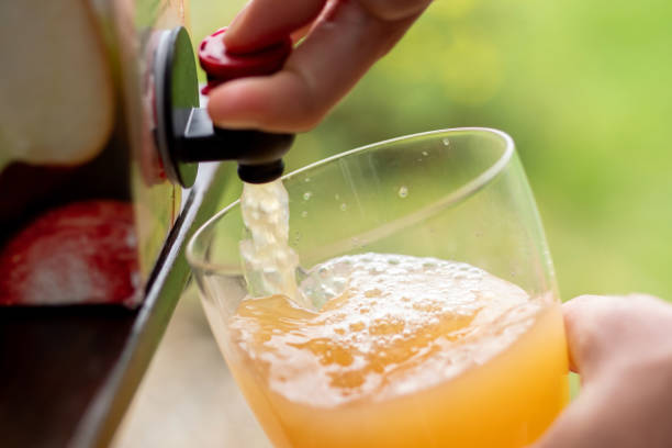 Vacuum boxed apple juice being poured into a glass.