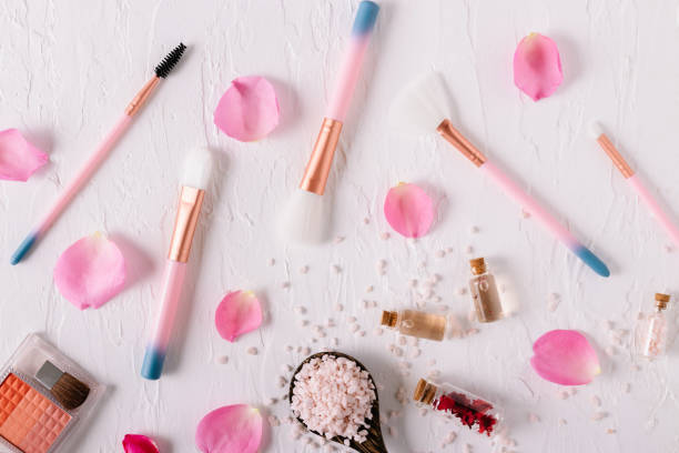 istock Top view of beautiful makeup brushes with rose petals on white background. 1179762865