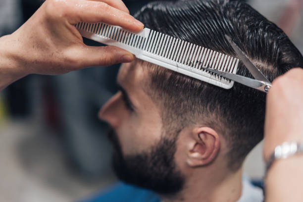 giovane uomo che sta ottenendo un taglio di capelli elegante - men hairdresser human hair hairstyle foto e immagini stock