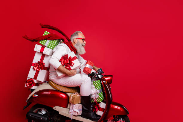 profile side view of nice attractive funky cheery bearded gray-haired man riding motor carrying pile stack new desirable purchase package air wind blowing isolated on bright vivid shine red background - active seniors enjoyment driveway vitality imagens e fotografias de stock