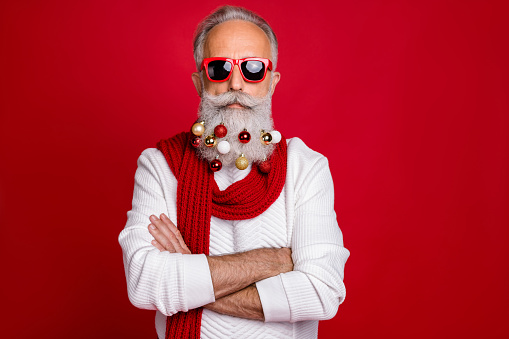 Portrait of cool retired, business man with eyeglasses eyewear crossing his hands wearing white sweater isolated over red background