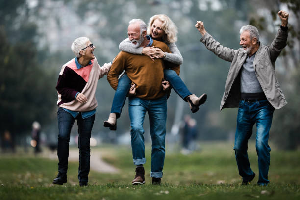 istock Playful mature couples having fun during autumn day in nature. 1179770081