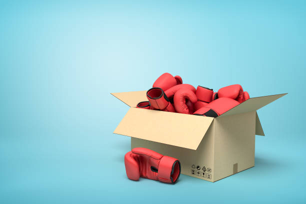 rendering 3d di scatola di cartone piena di guanti da boxe rossi su sfondo blu. - cardboard box immagine foto e immagini stock