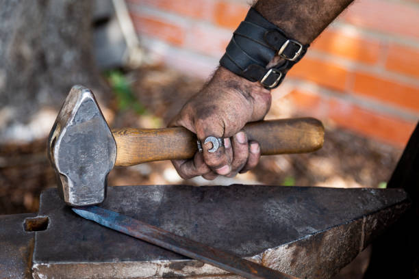 istock Blacksmith working on metal on anvil at forge detail shot 1179770944