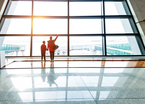 istock Mother and son looking through the window at airport 1179770985