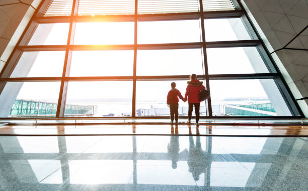 istock Mother and son looking through the window at airport 1179771567