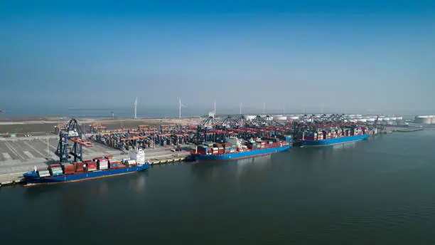 Aerial view of container terminal in the harbor MAASVLAKTE, Netherlands. A large containership from Cosco is unloading