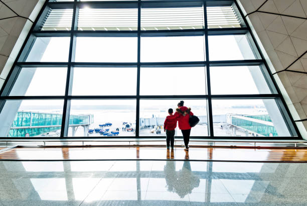 istock Mother and son looking through the window at airport 1179771736