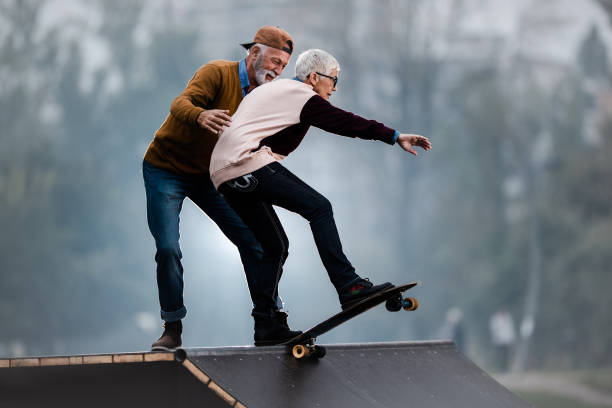 young at heart senior couple having fun at skate park. - skateboard park ramp skateboarding park imagens e fotografias de stock