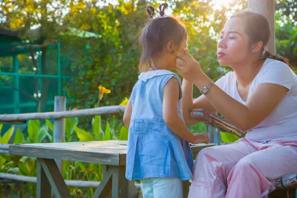 young mother soothing a crying little daughter, Asian mother trying to comfort and calm down her crying child.  High resolution image gallery.