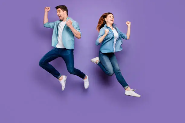 Full size photo of funny funky crazy brown hair redhair lucky spouses jump, raise fists scream yeah celebrate luck discounts wear good-looking clothes isolated over purple color background