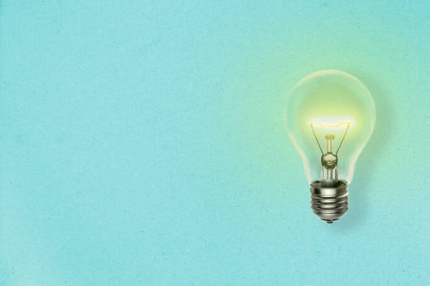 istock Idea concept background with lit light bulb on a blue paper sheet and copy space for your text 1179776007