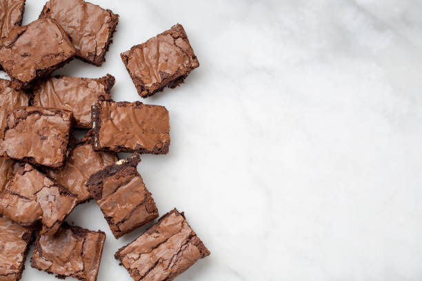 Chocolate brownies cakes deserts on a white marble background looking down top view