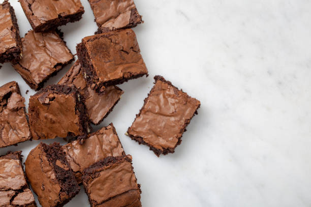 istock Chocolate brownies cakes deserts on a white marble background looking down top view 1179777307