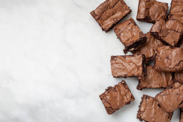 schokolade brownies kuchen wüsten auf einem weißen marmor hintergrund blick nach unten ansicht - brownie baked bakery brown stock-fotos und bilder