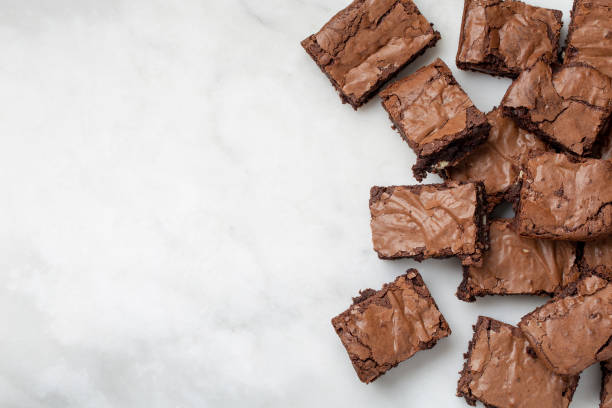 istock Chocolate brownies cakes deserts on a white marble background looking down top view 1179777348