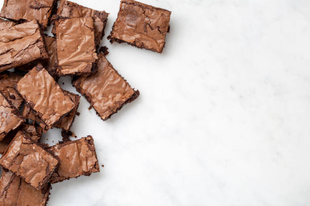 istock Chocolate brownies cakes deserts on a white marble background looking down top view 1179777350