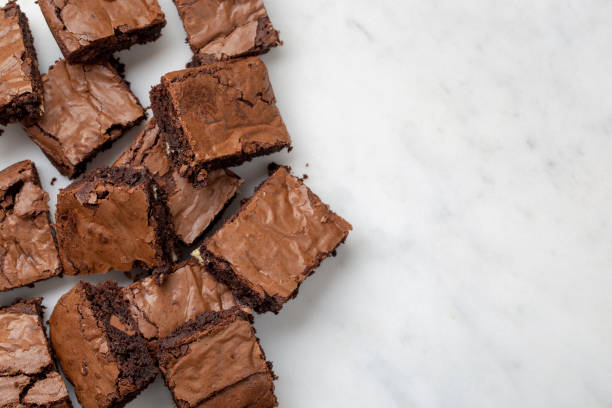 istock Chocolate brownies cakes deserts on a white marble background looking down top view 1179777360
