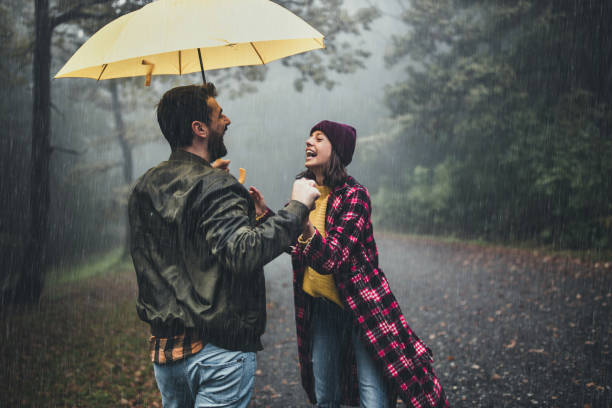 istock Cheerful couple having fun while talking on a rainy day. 1179779606