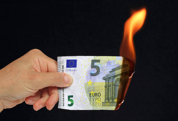 istock hand holding a burning euro bank note 1179780990