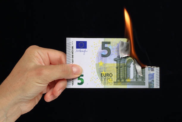 istock hand holding a burning euro bank note 1179780994