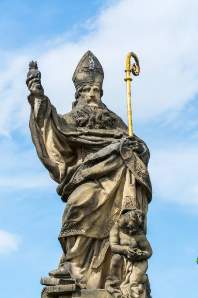 istock Saint Augustin statue, on Charles Bridge, Prague ,  The statue depicts a philosopher holding a hook and a burning heart, with an accompanying angel beside him. 1179785592